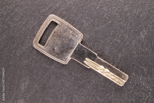 One metal key on a slate stone, macro, top view. © Oleksandr