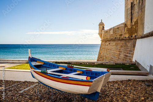 Foto The wooden traditional boat and Saint James Fortress on the beach of Sesimbra, P