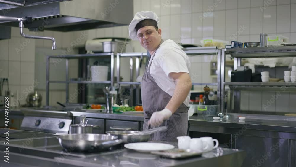 Portrait of professional chef in cook hat and apron adding sugar in cooking pan turning pineapple slice. Concentrated expert Caucasian man preparing tasty dinner in commercial kitchen in restaurant Portrait of professional chef in cook hat and apron adding sugar in cooking pan turning pineapple slice. Concentrated expert Caucasian man preparing tasty dinner in commercial kitchen in restaurant