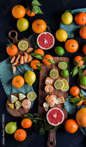 Frische Orangen auf schwarzem Hintergrund, Auswahl Orange, Mandarine, Zitrone, Limette, geschnittene und halbierte Früchte