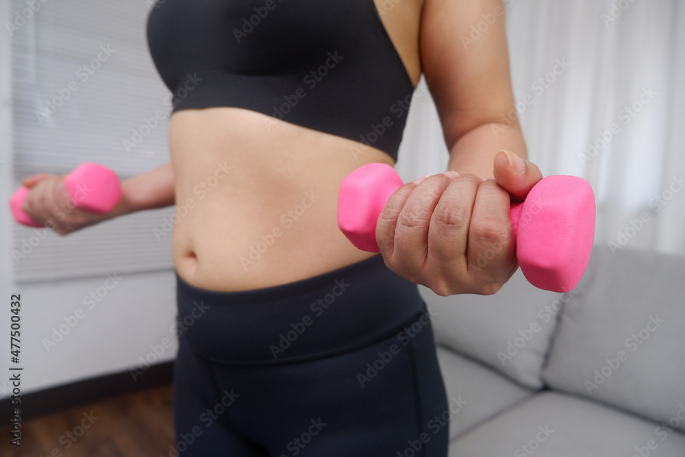 Women doing exercise at home using dumbbell for exercise arms and upper body. Women doing exercise at home using dumbbell for exercise arms and upper body.