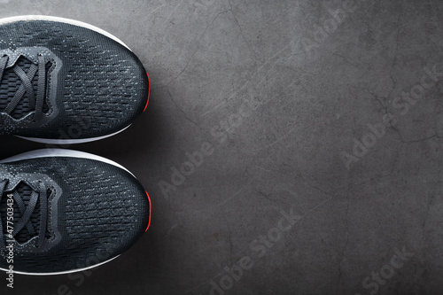 Black running shoes with mesh and black laces close-up on a dark background