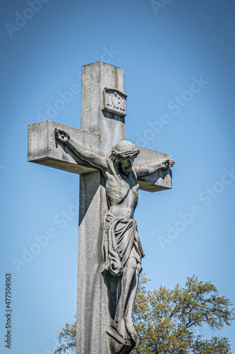 Jesus on the cross. Cemetery. Blue sky.