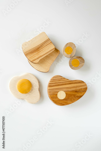 wooden toy food includes eggs, steak and bread on white backgrownd. Play for preschool children.