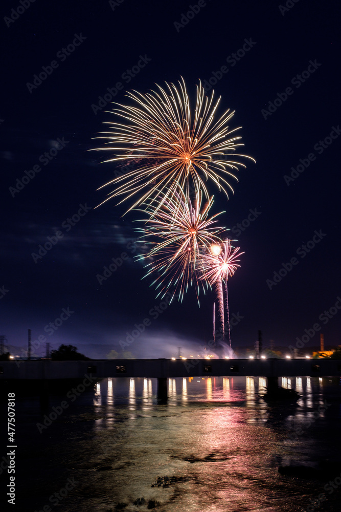 Fireworks over river with bridge and reflections. Fireworks over river with bridge and reflections.