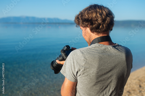 Male photographer standing by the sea