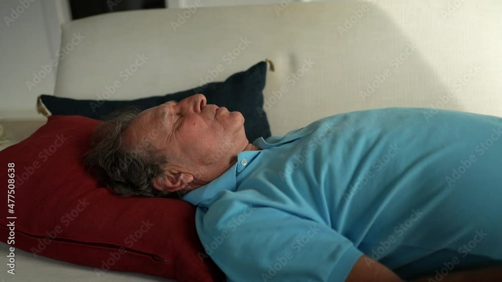 Older man lying in sofa resting. Senior person napping Older man lying in sofa resting. Senior person napping