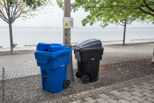 Photography Blue recycling bin and a black litter bin along a waterfront path on a foggy autumn day