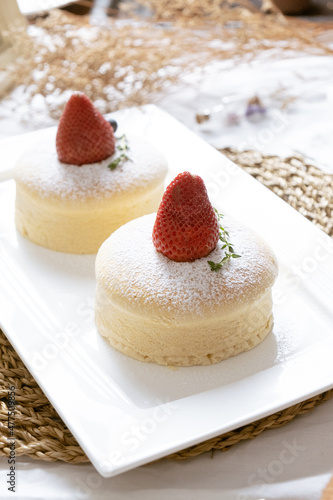 Delicious Japanese fluffy souffle pancakes on white cafe table. © Tavan