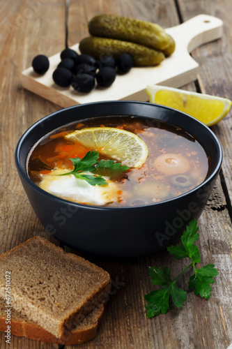 Traditional russian meat soup Solyanka in a bowl and ingredients