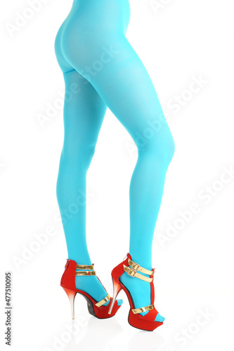 Side view of female legs in nylon tights and high-heels on isolated white background