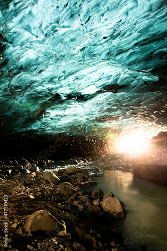 Ice Cave with river and sun burst, Iceland.