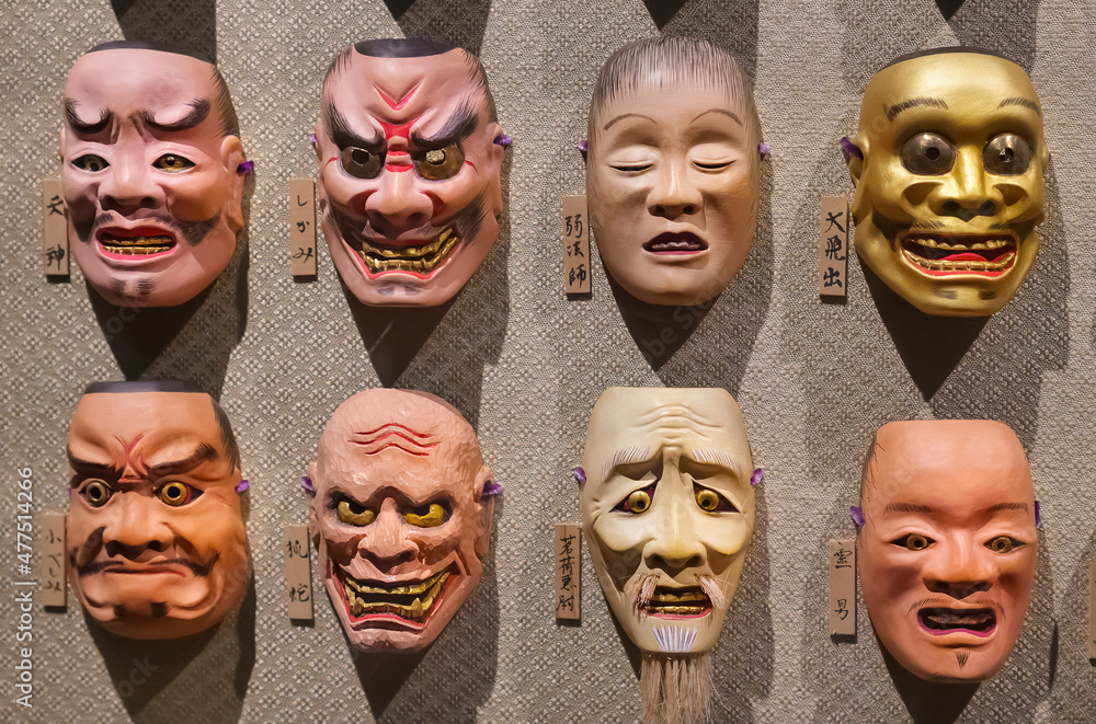 tokyo, japan july 18 2021 Eight Japanese Noh theater masks hung in rows on a wall depicting