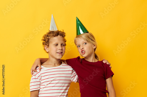 Portrait of cute children in casual clothes with caps on the head on colored background
