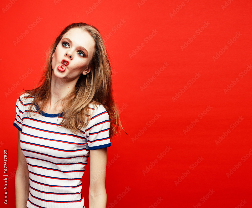 young pretty emitonal posing teenage girl on bright red background, happy smiling lifestyle people concept young pretty emitonal posing teenage girl on bright red background, happy smiling lifestyle people concept
