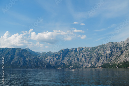 Motor boat sails along the Bay of Kotor leaving a white foamy trail