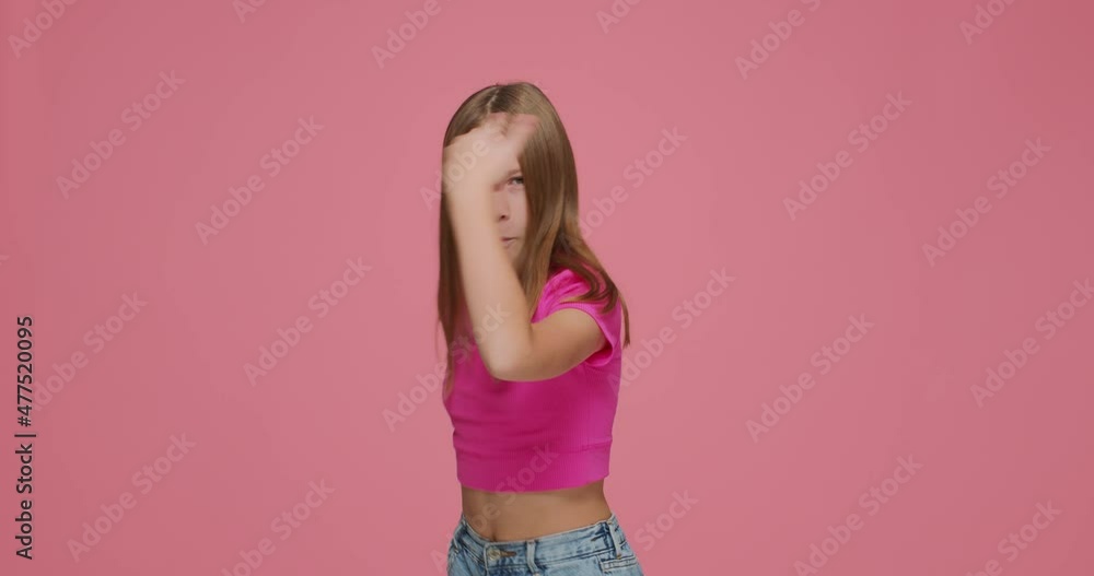 Funny joyful child girl show rock gesture by hands, having fun. Kid rocker make death horns sign on pink background Funny joyful child girl show rock gesture by hands, having fun. Kid rocker make death horns sign on pink background