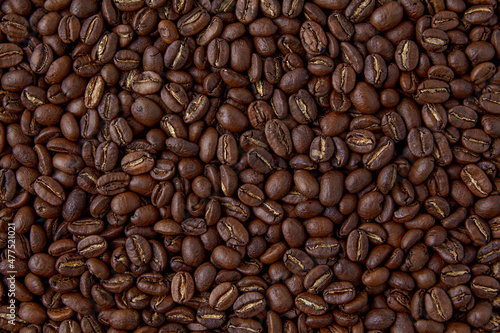 A background of randomly scattered roasted coffee beans. Presentation layout.