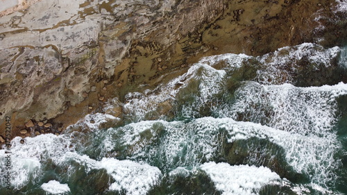 Waves crashes on a rocky beach. Aerial view