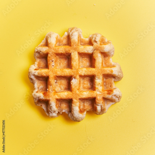  Single delicious waffle over yellow background photo