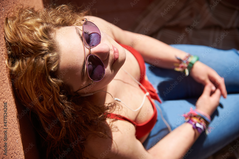 Naklejka premium Caucasian girl sunbathing with sunglasses overhead view