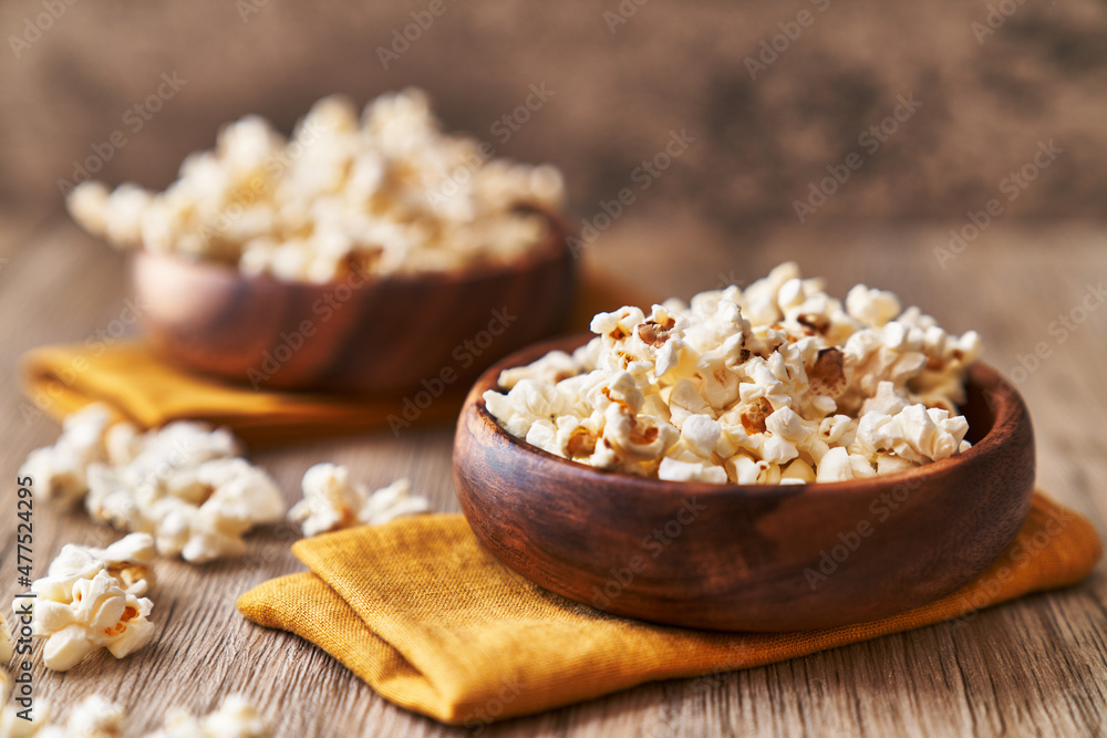 Bowls of salty popcorns on a wooden surface Bowls of salty popcorns on a wooden surface