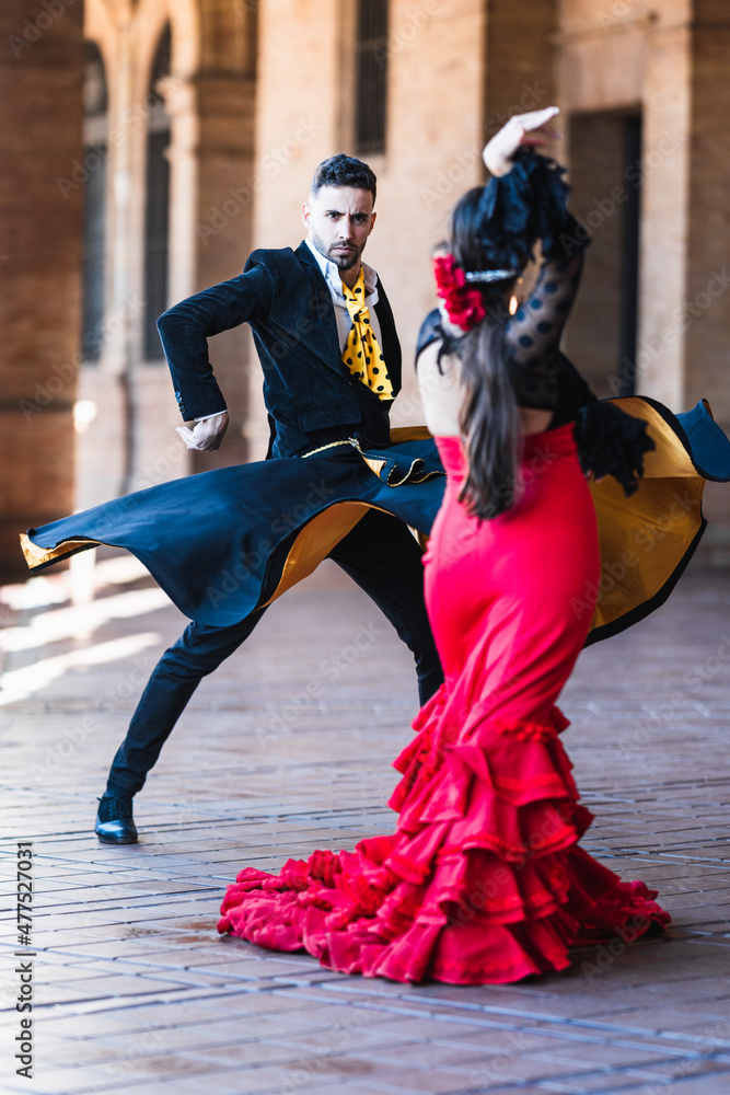 Fototapeta premium Man with a cape dancing flamenco with a woman in dress outdoors