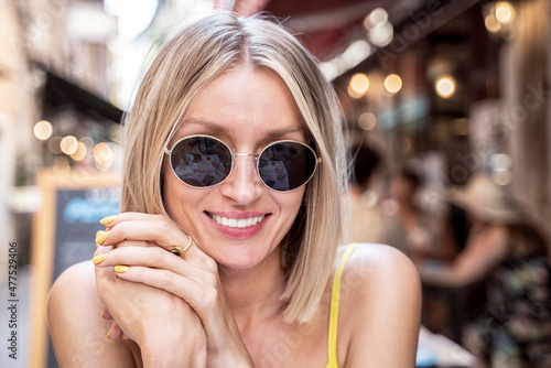 Closeup portrait of smiling blonde beautiful caucasian woman in fashionable sunglasses.
