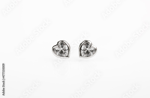 Hearts-shaped silver stud earrings on white background © Victoria Key
