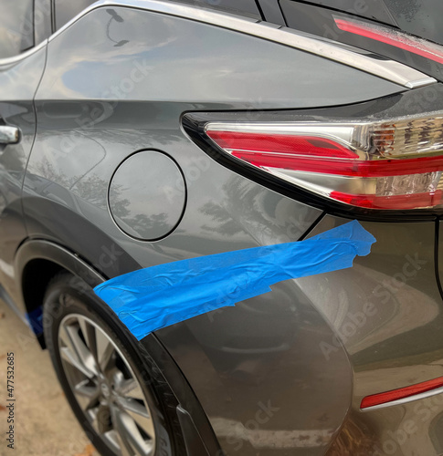 Rear Bumper broken. After the accident put blue adhesive tape on bumper and vehicle body. at the parking lot.