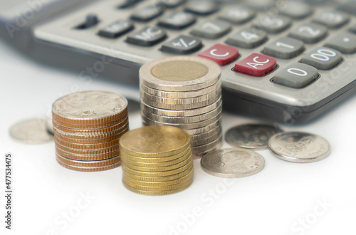 Coin stack with calculator on isolate white background