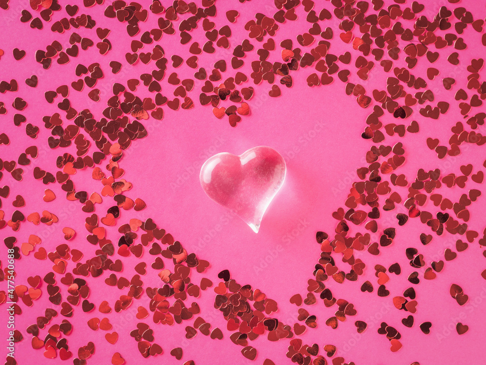 Abstract image of a glass heart on the background of scattered small hearts. The concept of Valentine's Day.