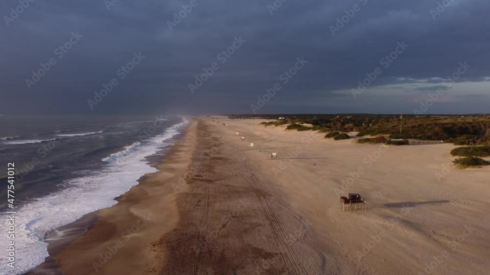 Aerial view of beautiful empty sandy beach and Ocean waves with dramatic dark clouds at sky,4K Aerial view of beautiful empty sandy beach and Ocean waves with dramatic dark clouds at sky,4K