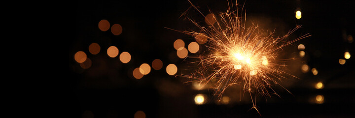 Happy New Year background with glowing sparklers.