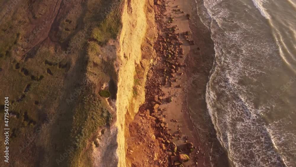 Slow motion shot of the Cliffs at sunset, beautiful top down view of the water waves moving too and fro  in Acantilados Mar del Plata, South America