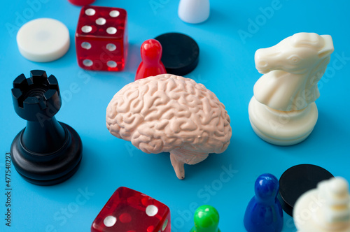 Learn through play, intelligence development and solve puzzle games concept with chess plastic figure, dice and board game figurines isolated on blue background
