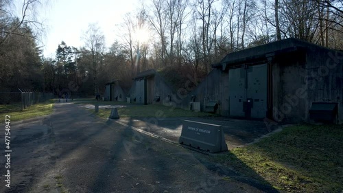 Beautiful view of old ammunition bunkers with sun shining low through trees photo