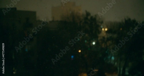 Falling snow in the city by dark night. photo