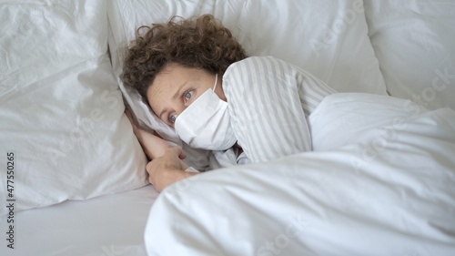 Isolated woman suffering from coronavirus infection, fever, cough, pain, staying in bed on covid-19 quarantine