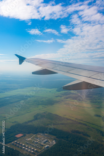 View from the airplane window at a beautiful blue sunrise and the airplane wing in clear sky.