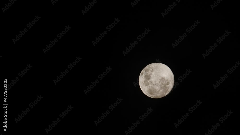 Slow, right to left reveal of full moon as clouds pass in front. Dark night sky Slow, right to left reveal of full moon as clouds pass in front. Dark night sky