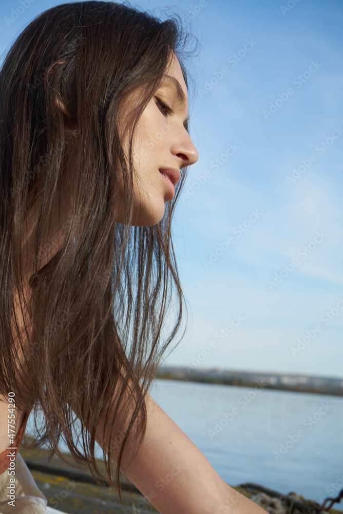 A young attractive woman of model appearance rests under a blanket on a pier. long hair. High quality photo A young attractive woman of model appearance rests under a blanket on a pier. long hair. High quality photo