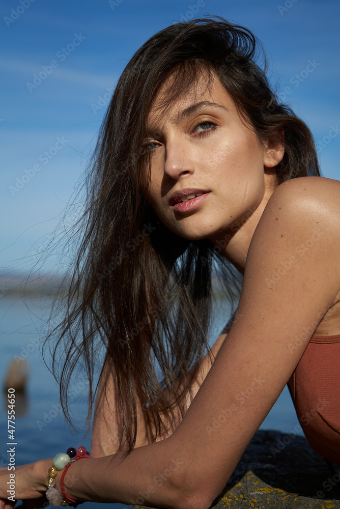 A young attractive woman of model appearance rests under a blanket on a pier. long hair. High quality photo