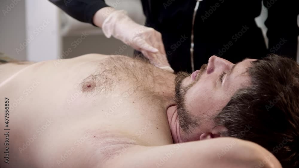 Waxing procedure - the master degreasing the chest of her male client Waxing procedure - the master degreasing the chest of her male client
