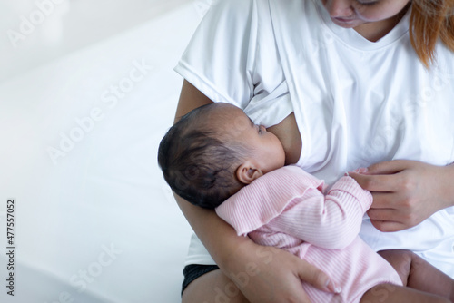 Mother breastfeeding newborn baby in her arms at home,  Concept of lactation infant, newborn baby and mom concept