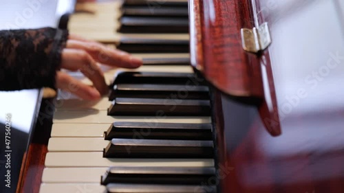 Woman playing on vintage wooden piano photo