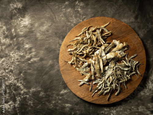 Dried anchovies in various types on a wooden plate