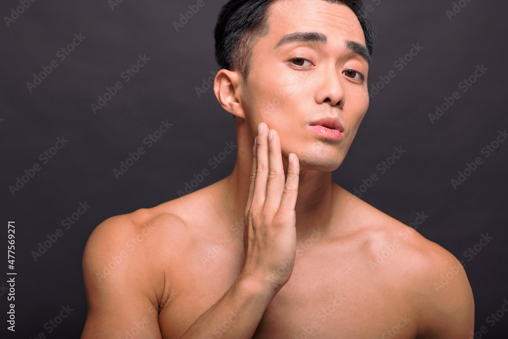 Close up of satisfied confident handsome guy touching with shaved flawless clean soft skin Close up of satisfied confident handsome guy touching with shaved flawless clean soft skin