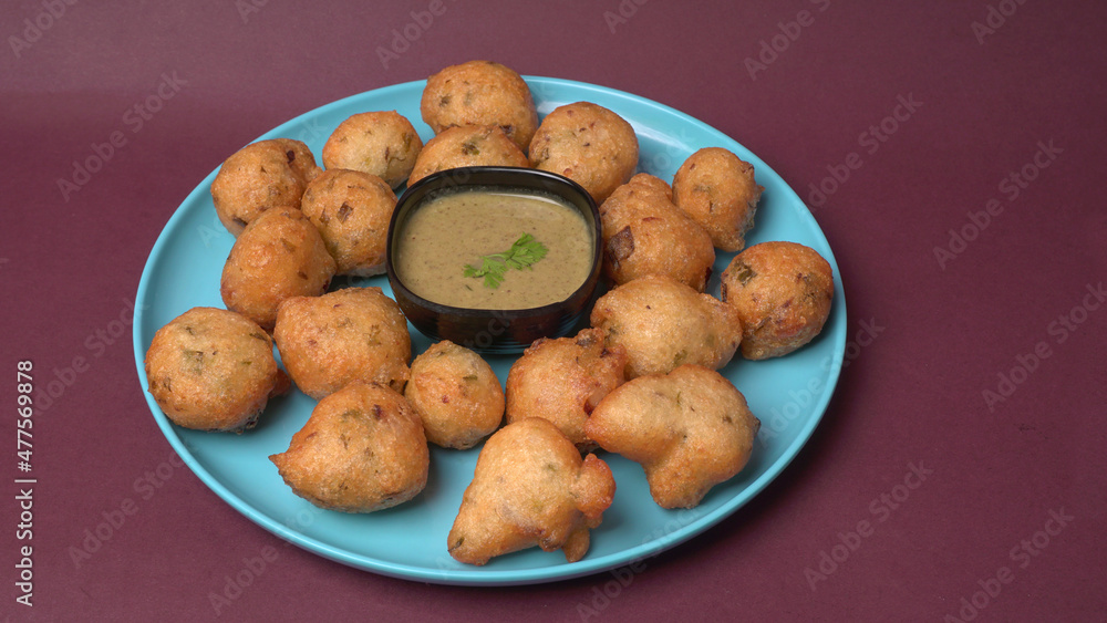 Delicious Indian snacks Punugulu served in a plate with Tomato and green Chutney Delicious Indian snacks Punugulu served in a plate with Tomato and green Chutney