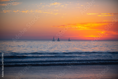 Calm sea with sunset sky and sun through the clouds over. Ocean and sky background, seascape. © Volodymyr
